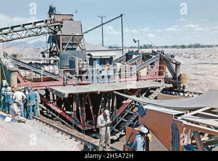 Travaux de construction sur le canal Wellton-Mohawk, près de Yuma, en Arizona, aux États-Unis, au début des années 1950.Ici, les travailleurs utilisent la machine de revêtement de canal, un dispositif mécanique géant sur des rails qui pose du béton, versé de la trémie à son sommet,Le district d'irrigation et de drainage Wellton-Mohawk, situé dans le sud-ouest de l'Arizona, à l'est de Yuma, est construit entre 1949 et 1957.Il permet l'irrigation dans la vallée inférieure de Gila avec de l'eau du fleuve Colorado via le canal de Gila jusqu'au canal Wellton-Mohawk, où il est pompé à environ 160 pieds. Banque D'Images