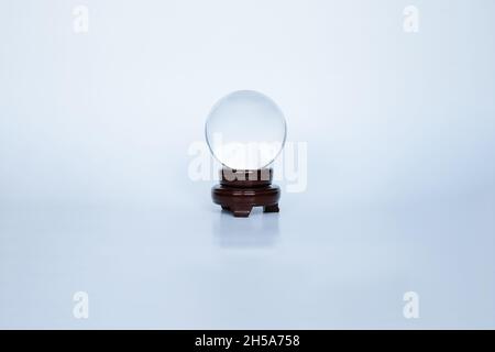 boule en cristal avec podium en bois sombre sur fond blanc.Divination et tueur de fortune Banque D'Images