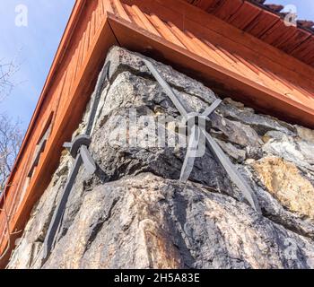 Stockholm, Suède - 6 avril 2021 : vue vers le haut sur les plaques d'ancrage en fer sur le sol en pierre avec façade en bois au-dessus Banque D'Images