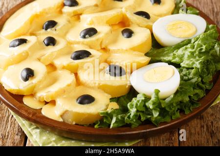 Papa a la Huancaina est un apéritif péruvien classique de pommes de terre étouffées d'un délicieux fromage et d'une sauce au Chili dans l'assiette sur la table. Banque D'Images