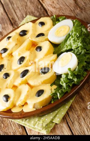 Papa a la Huancaina pommes de terre de style Huancayo avec des œufs durs à la carte sur la table.Verticale Banque D'Images