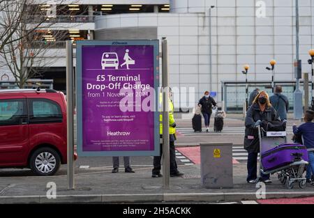 Les passagers doivent passer un panneau d'information au terminal 3 de l'aéroport d'Heathrow, Londres, pour signaler les nouveaux frais de dépôt pour les personnes transportant des voyageurs vers l'aéroport en véhicule.Date de la photo: Lundi 8 novembre 2021. Banque D'Images