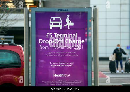 Les passagers doivent passer un panneau d'information au terminal 3 de l'aéroport d'Heathrow, Londres, pour signaler les nouveaux frais de dépôt pour les personnes transportant des voyageurs vers l'aéroport en véhicule.Date de la photo: Lundi 8 novembre 2021. Banque D'Images