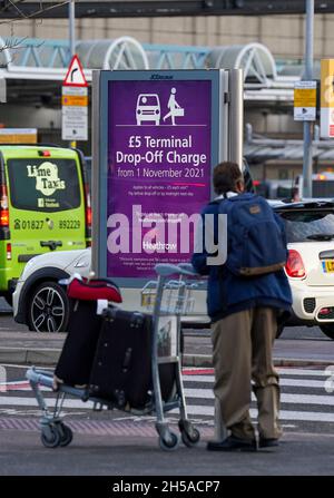 Les passagers doivent passer un panneau d'information au terminal 3 de l'aéroport d'Heathrow, Londres, pour signaler les nouveaux frais de dépôt pour les personnes transportant des voyageurs vers l'aéroport en véhicule.Date de la photo: Lundi 8 novembre 2021. Banque D'Images