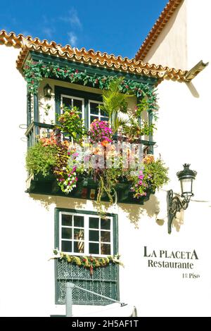 Santa Cruz de la Palma, Îles Canaries - 8 décembre 2019 : ancien balcon en bois avec beaucoup de plantes et décorations de noël sur un bâtiment de restaurant. Banque D'Images