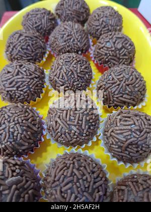 Brigadier (brigadeiro) : doux brésilien traditionnel.Sur fond jaune. Banque D'Images