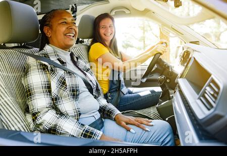 Des femmes gaies et diverses voyageant en minibus Banque D'Images