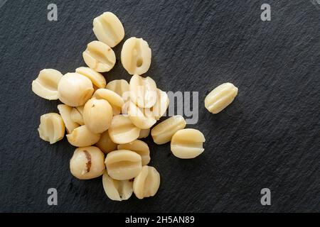 Graines de Lotus sucrées sur ardoise.Haricots en conserve comme la nourriture traditionnelle asiatique, encas sur surface noire, vue du dessus Banque D'Images
