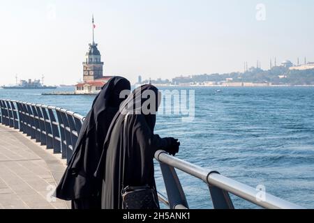 Deux femmes vêtues de robes musulmanes traditionnelles hijab noir, burqa et marchant dans le remblai d'Istanbul, Turquie Banque D'Images