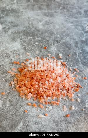 Tas de roche himalayenne rose gros sel sur fond gris Banque D'Images