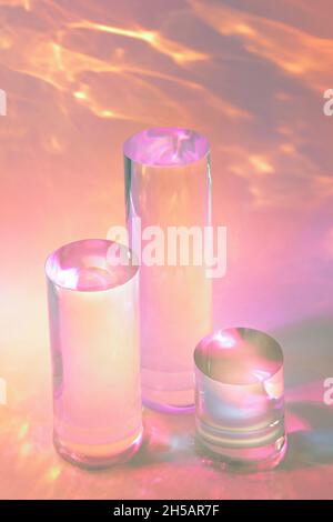 trois podiums en verre transparent sur fond rose pastel Banque D'Images