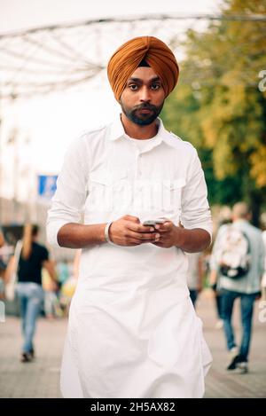 Kiev, Ukraine - 23 août 2021.Khreshchatyk St. Portrait du jeune homme indien adulte en turban vêtu de vêtements traditionnels blancs regardant un appareil photo Banque D'Images