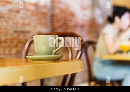 Tasse d'argile verte avec café sur table en bois dans le café. Banque D'Images