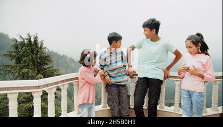 Quatre petits frères et sœurs de l'Inde s'amusant près du balcon à Shimla, Himachal Pradesh, Inde Banque D'Images