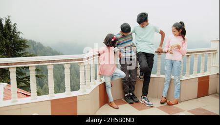 Quatre petits frères et sœurs de l'Inde s'amusant près du balcon à Shimla, Himachal Pradesh, Inde Banque D'Images