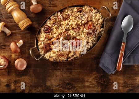 Risotto aux champignons, riz rustique avec divers champignons, plat sur fond de bois foncé avec espace de copie Banque D'Images