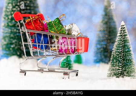 Shopping de Noël.Chariot de supermarché avec cadeaux du nouvel an.Carte de vœux du nouvel an Banque D'Images
