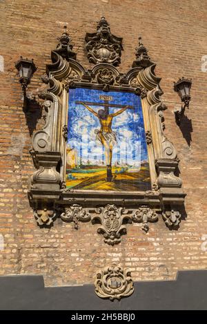 Azulejo montrant Jésus sur la croix sur un mur extérieur de l'Église de l'Annonciation (Iglesia de la Anunciacion) à Séville Espagne.L'église en R Banque D'Images