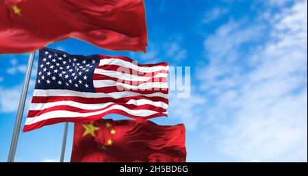 Le drapeau national des États-Unis agitant entre deux drapeaux de la Chine avec ciel clair en arrière-plan.Relations internationales et diplomatie. Banque D'Images