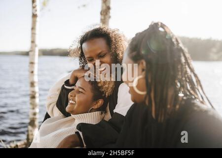 Des amies gaies s'amusant au bord du lac par beau temps Banque D'Images