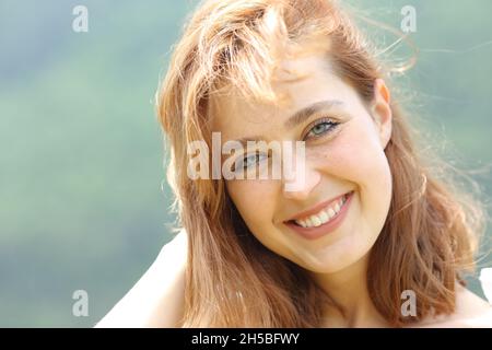 Vue avant portrait d'une femme heureuse posant regardant l'appareil photo dans la montagne Banque D'Images