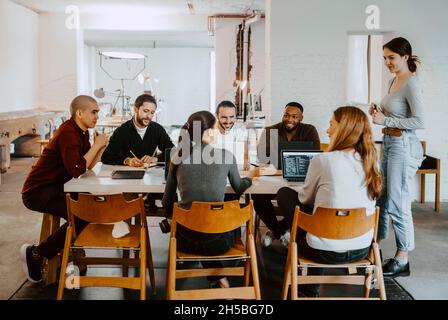 Femmes d'affaires souriantes et hommes d'affaires en réunion à la start-up Banque D'Images