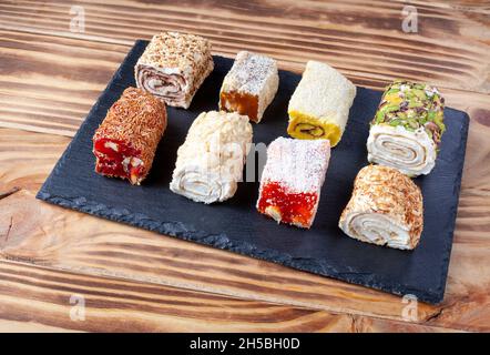 Délice turc.Assortiment de délices turcs aux saveurs variées et à la crème.Rouleaux de Lokum couverts de noix et de sucre en poudre.Bonbons à la gelée de fruits avec Banque D'Images