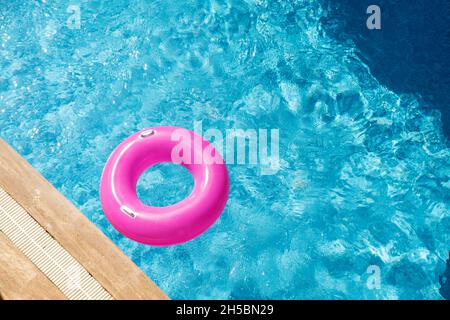 Anneau gonflable rose dans la piscine.Eau bleue rafraîchissante.Vue de dessus.Espace de copie - image Banque D'Images