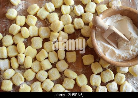 Gnocchi de pomme de terre cru non cuit, isolé sur une table en bois.Directement au-dessus.Cuisine maison. Banque D'Images