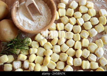 Gnocchi de pomme de terre cru non cuit, isolé sur une table en bois.Directement au-dessus.Cuisine maison. Banque D'Images