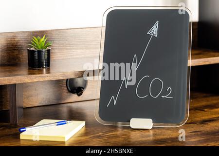 Tableau noir avec graphique croissant des émissions de co2 sur un bureau pour les jeunes.Le concept de sensibilisation accrue du public et la menace que représente la micl Banque D'Images