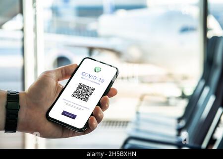 Le certificat Corona passe sur le vaccin Covid à l'aéroport.Passeport numérique covid19 dans le téléphone.Avion dans la fenêtre avant le vol international. Banque D'Images