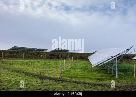 Une ferme solaire derrière un petit parc d'affaires près de Denholme dans le West Yorkshire , Royaume-Uni, située dans les champs et les terres agricoles sur la lande derrière le parc d'affaires. Banque D'Images