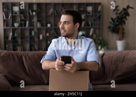 Un jeune homme heureux qui pense à une critique positive. Banque D'Images