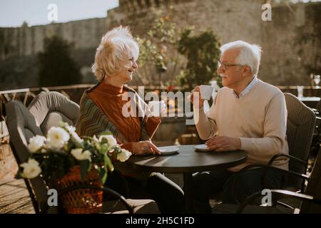 Un couple de personnes âgées en bonne santé qui boit du café en plein air le jour ensoleillé de l'automne Banque D'Images