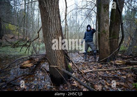 Jason Voorhees, tueur en série, dans un masque de hockey sur le marais de la forêt d'automne.Vendredi 13h Cosplay costume. Banque D'Images