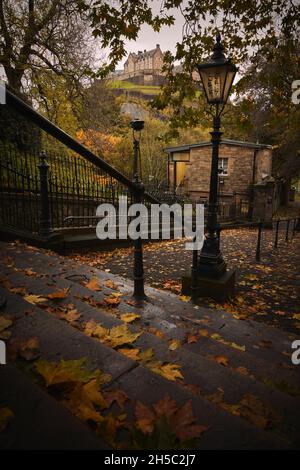 Château d'Édimbourg depuis les marches descendant jusqu'à la cour de l'église paroissiale de St Cuthbert, Kirk à côté des jardins de Princes Street.Heure d'automne. Banque D'Images