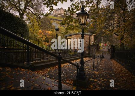 Château d'Édimbourg depuis les marches descendant jusqu'à la cour de l'église paroissiale de St Cuthbert, Kirk à côté des jardins de Princes Street.Heure d'automne. Banque D'Images