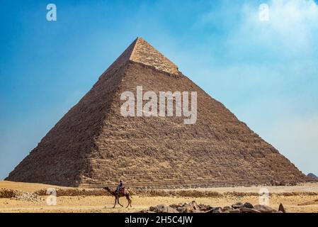 GIZA, ÉGYPTE - 14 JUILLET 2021 : une personne passe à dos de chameau près de la Grande Pyramide de Giza, Égypte Banque D'Images