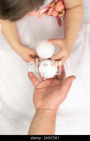 Le concept de la préparation de la nouvelle année avec la famille.Le père et la fille tiennent deux boules de Noël décoratives blanches décorant le Banque D'Images