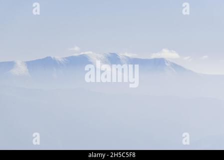 Vue sur les pics de la crête de Borzhava couverte de nuages blancs sous un ciel bleu clair le jour d'automne chaud d'octobre.Région de Lviv, Ukraine Banque D'Images