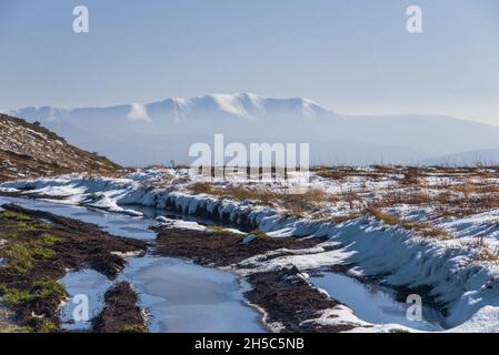 Vue sur les sommets enneigés de la crête de Borzhava recouverte de neige sous le ciel bleu le jour d'automne chaud d'octobre.Région de Lviv, Ukraine Banque D'Images