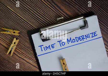 Il est temps de moderniser l'écriture sur une paperasse isolée sur une table en bois. Banque D'Images