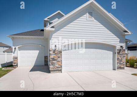 Extérieur de garage pour trois voitures avec deux portes de garage blanches avec ouvertures de porte voûtées Banque D'Images