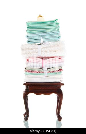 Table de style queen ann avec pile de draps anciens isolés sur fond blanc Banque D'Images