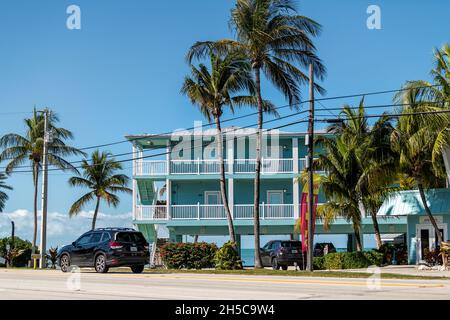 Islamorada, Etats-Unis - 26 janvier 2021: Blue maison de vacances appartements sur pilotis bord de mer sur la plage de l'océan Atlantique en Floride avec des palmiers et des voitures Banque D'Images