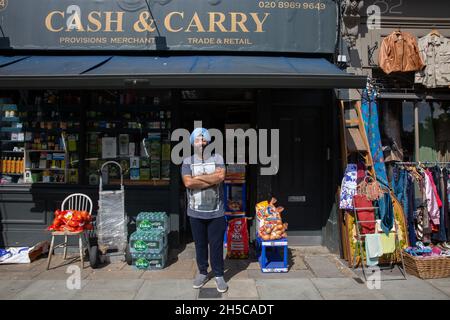 Un commerçant sikh à l'extérieur de son magasin de caisse et de porte sur Golborne Road dans l'ouest de Londres, en Angleterre.Photo: NOUVELLES SMP Banque D'Images