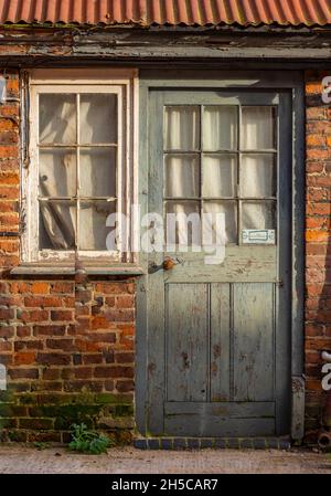 ancienne porte et fenêtre en brique avec toit en fer ondulé ou en étain rouillé. bâtiment rustique vintage, ancienne construction rurale, atelier chic et chic. Banque D'Images