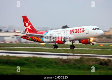 Air Malta Airbus A320-214 (REG: 9H-AEQ) atterrissage sur la piste 13 après le coucher du soleil. Banque D'Images