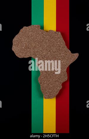 Concept du mois de l'histoire du noir.Afrique de forme continent avec barre de couleurs traditionnelle rouge, jaune et vert.Espace pour votre texte.Pose à plat.Photo verticale. Banque D'Images